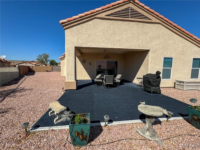 back of house with a fenced backyard, a patio, and stucco siding