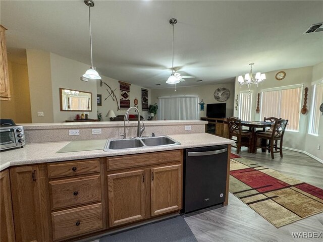 kitchen with black dishwasher, light countertops, a sink, and visible vents