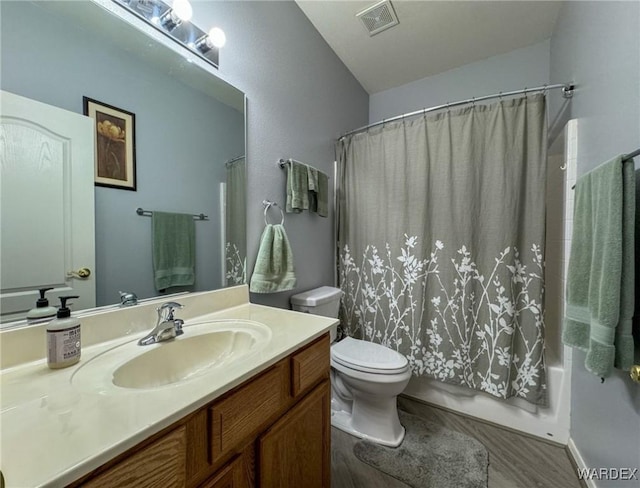 full bath featuring visible vents, toilet, shower / tub combo, vanity, and wood finished floors