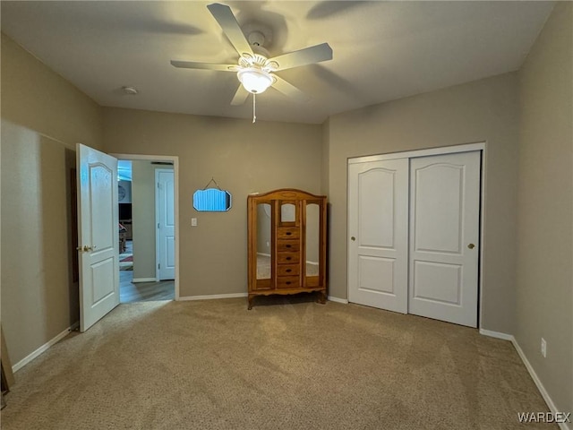 unfurnished bedroom with a ceiling fan, a closet, light colored carpet, and baseboards