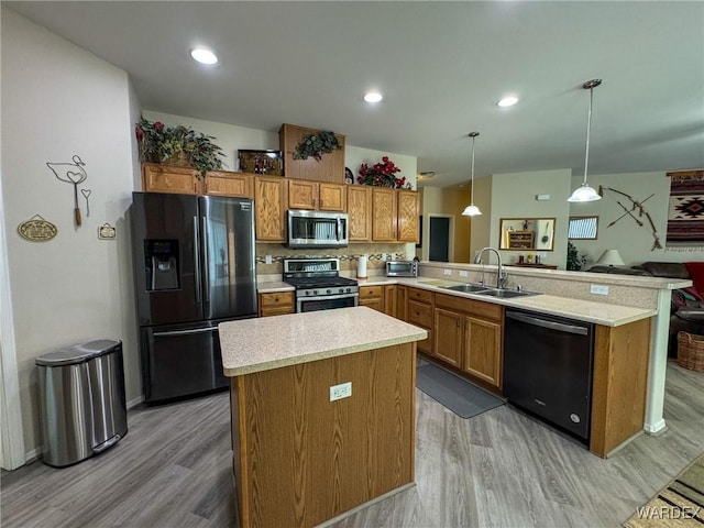 kitchen featuring decorative light fixtures, light countertops, a peninsula, and black appliances