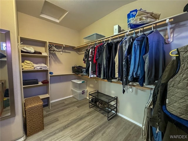 spacious closet with attic access and wood finished floors