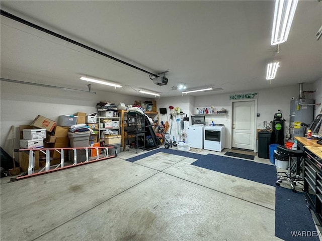 garage featuring water heater, a workshop area, washer and clothes dryer, and a garage door opener