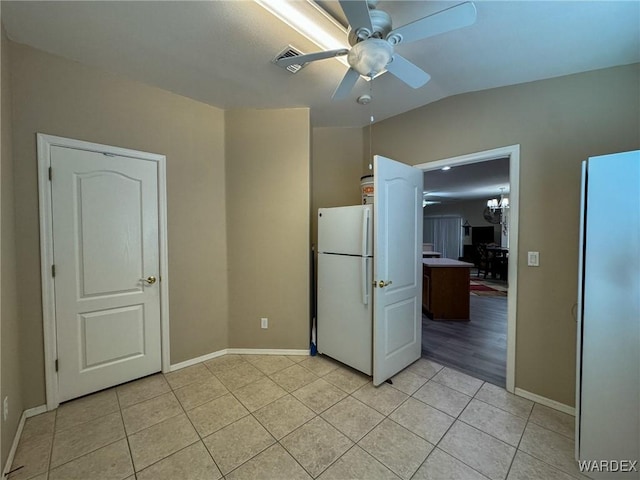 interior space featuring light tile patterned floors, ceiling fan, lofted ceiling, visible vents, and baseboards