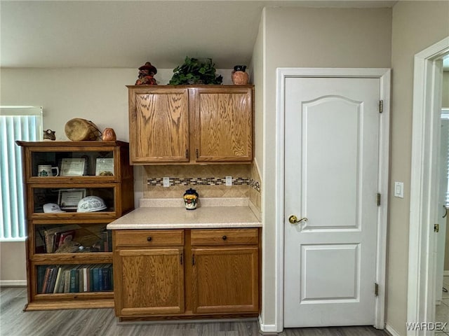 bar featuring baseboards, light wood-style floors, and decorative backsplash