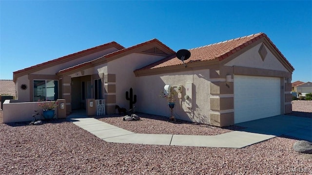 view of front of house featuring driveway, a tiled roof, an attached garage, and stucco siding