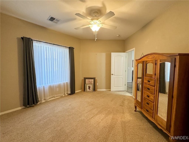 unfurnished bedroom with ceiling fan, carpet floors, visible vents, and baseboards