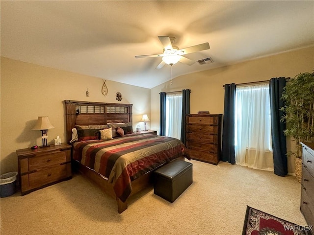 bedroom featuring visible vents, vaulted ceiling, a ceiling fan, and light colored carpet