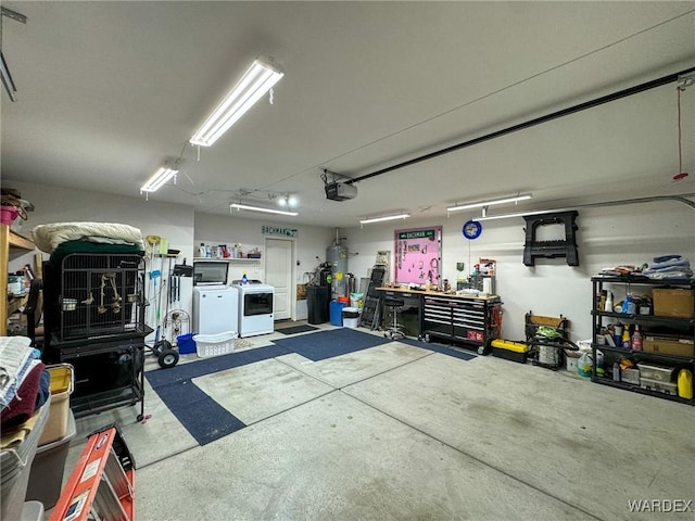 garage with water heater, a garage door opener, a workshop area, and washing machine and clothes dryer