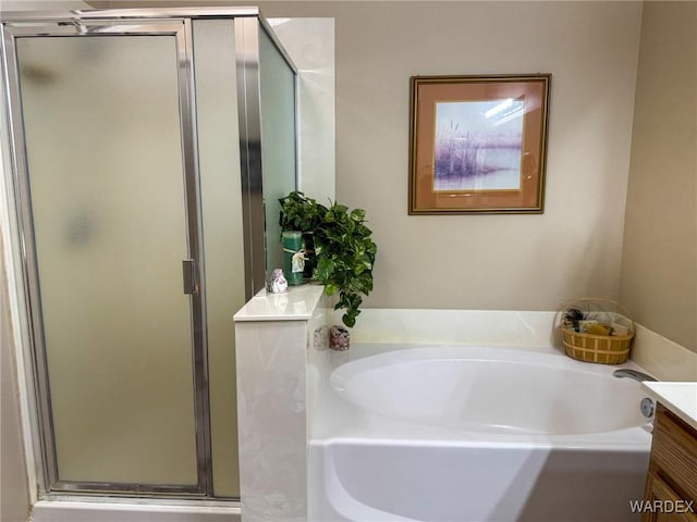 full bathroom with a stall shower, vanity, and a bath