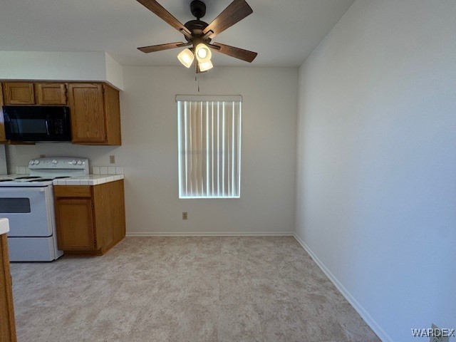 1280 Mohave Dr Unit 8A, Bullhead City, AZ 86442 - kitchen with a ceiling fan, brown cabinetry, tile counters, electric stove, and black microwave