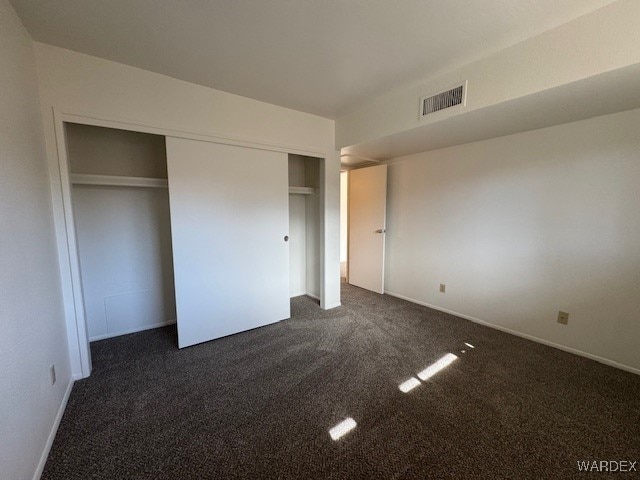 1280 Mohave Dr Unit 8A, Bullhead City, AZ 86442 - unfurnished bedroom featuring a closet, visible vents, and dark carpet