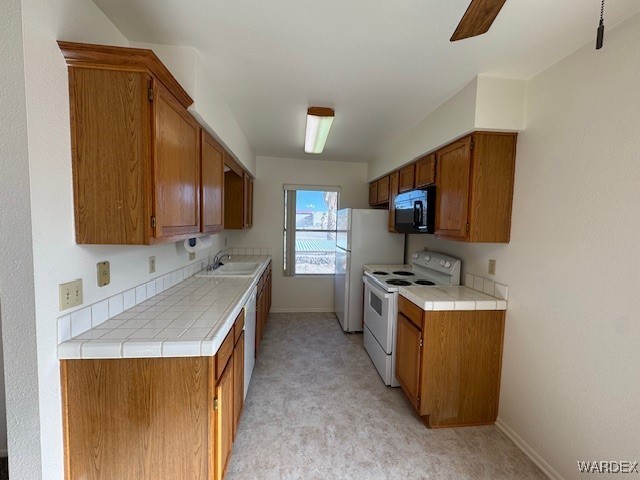 1280 Mohave Dr Unit 8A, Bullhead City, AZ 86442 - kitchen with brown cabinets, white appliances, baseboards, and a sink