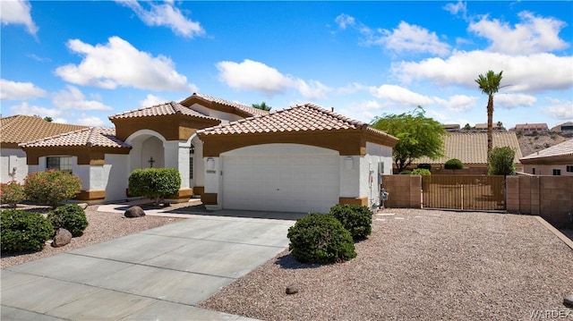 mediterranean / spanish-style house with a garage, concrete driveway, a tile roof, fence, and stucco siding