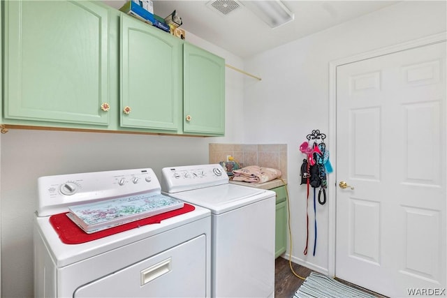 laundry area with visible vents, washing machine and clothes dryer, cabinet space, and dark wood-style floors