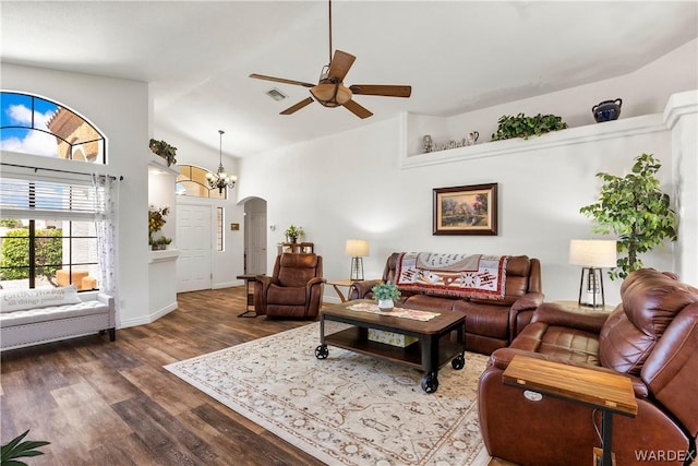 living room with arched walkways, dark wood-style flooring, visible vents, ceiling fan, and high vaulted ceiling