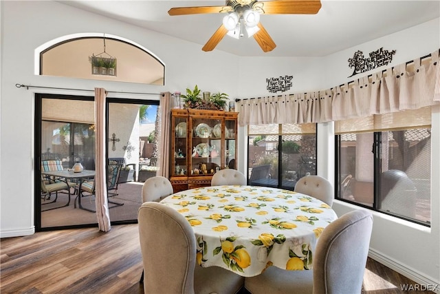 dining space with a ceiling fan, baseboards, and wood finished floors