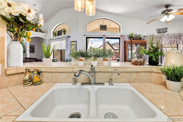 interior details featuring ceiling fan, light countertops, and a sink