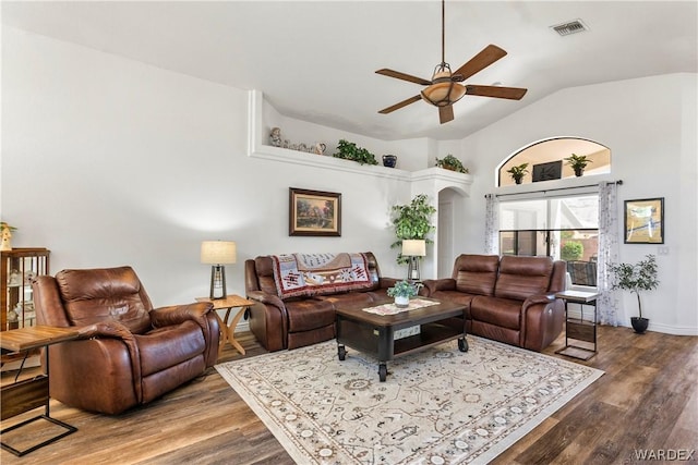 living area featuring visible vents, arched walkways, a ceiling fan, lofted ceiling, and wood finished floors