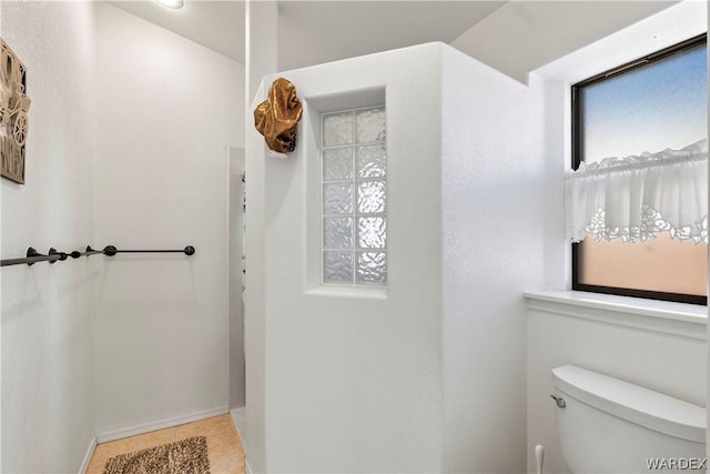 bathroom with toilet and tile patterned floors