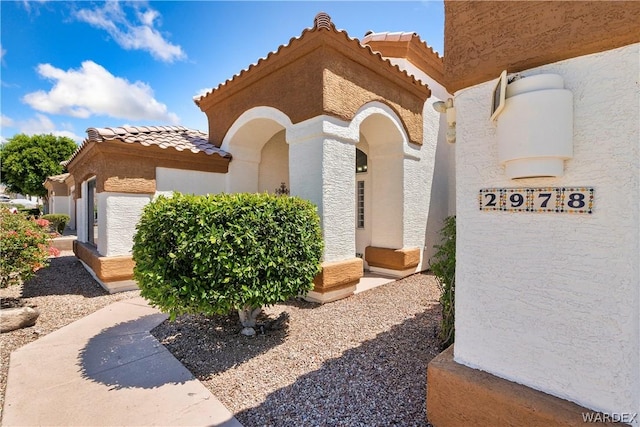 exterior space featuring a tiled roof and stucco siding