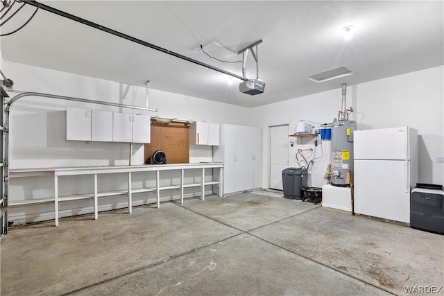 garage featuring a garage door opener, gas water heater, and freestanding refrigerator