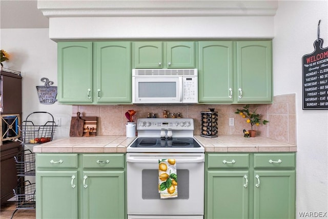 kitchen with tasteful backsplash, tile counters, white appliances, and green cabinets