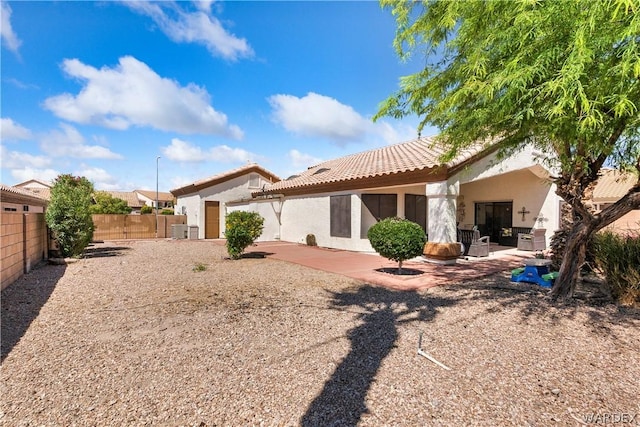 back of house featuring a fenced backyard, a patio, and stucco siding