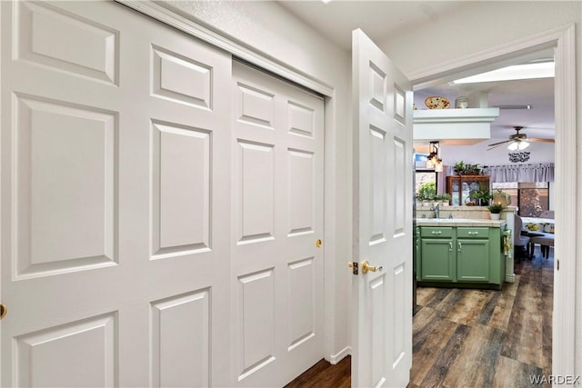 hall with dark wood-type flooring and a sink