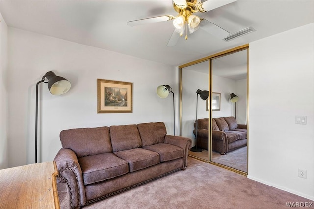 carpeted living room with a ceiling fan and visible vents