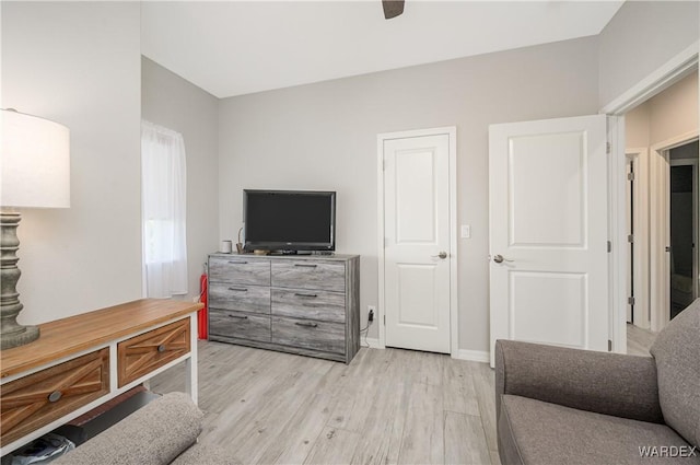 interior space with light wood-style floors, baseboards, and a ceiling fan