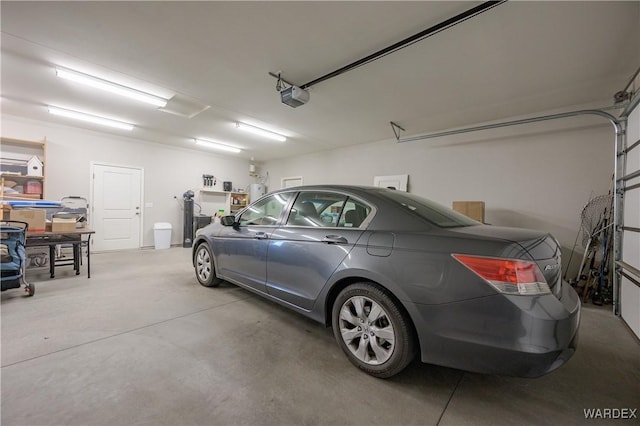 garage with water heater and a garage door opener