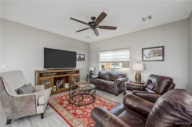 living room with light wood-style floors, ceiling fan, and visible vents