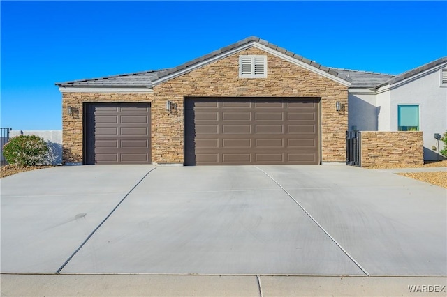 single story home with driveway, stone siding, a tile roof, and a garage