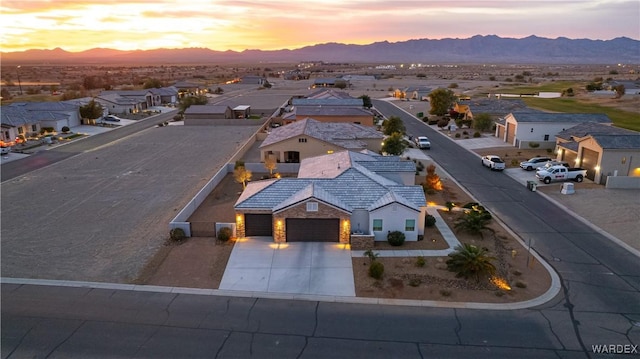 aerial view at dusk featuring a residential view and a mountain view