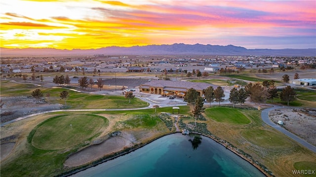 aerial view at dusk featuring a water and mountain view