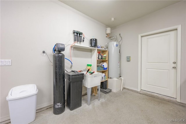 laundry area with baseboards and electric water heater