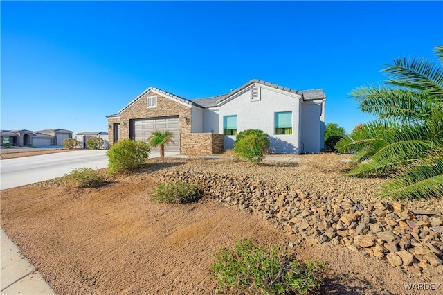 ranch-style house featuring a garage, stone siding, concrete driveway, and stucco siding