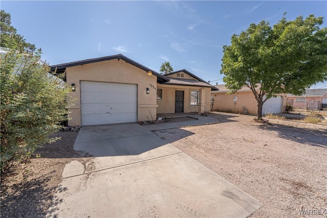 single story home with driveway, an attached garage, and stucco siding