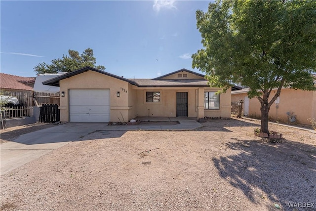 single story home featuring concrete driveway, fence, an attached garage, and stucco siding