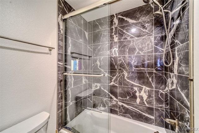 full bath with toilet, a textured wall, and enclosed tub / shower combo