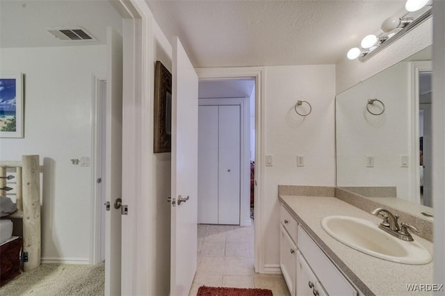 bathroom with visible vents, a textured ceiling, tile patterned floors, and vanity