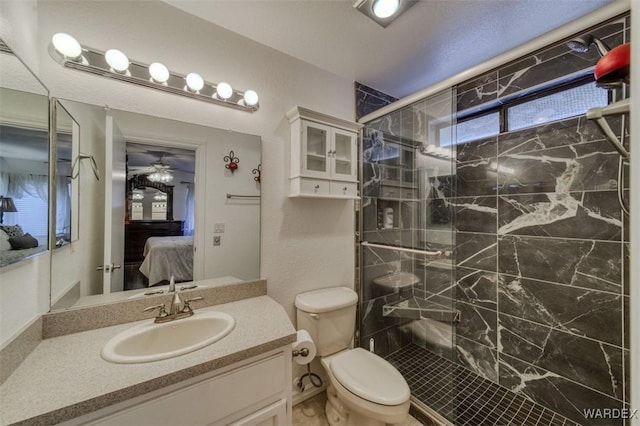 bathroom featuring vanity, toilet, a ceiling fan, a shower stall, and ensuite bathroom