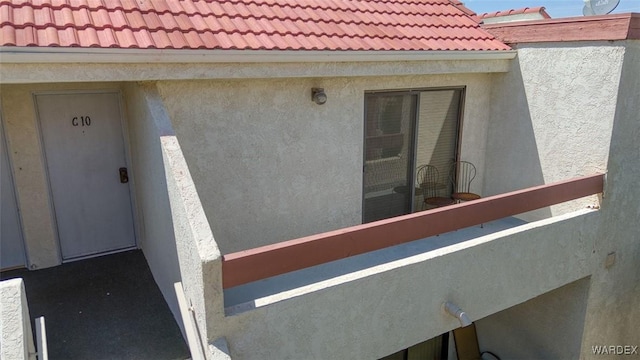 exterior space with stucco siding and a tiled roof