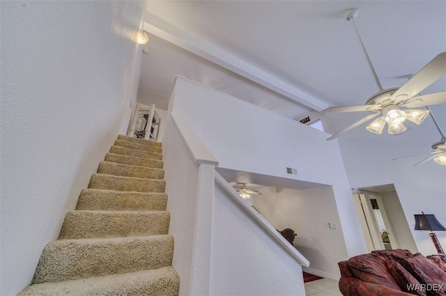 stairs featuring visible vents, lofted ceiling with beams, and ceiling fan