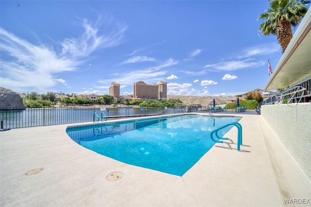 community pool featuring a patio, fence, and a water view