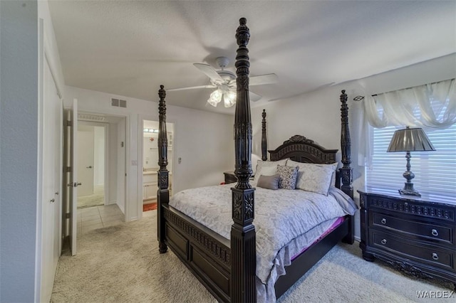 bedroom with light carpet, a ceiling fan, and visible vents