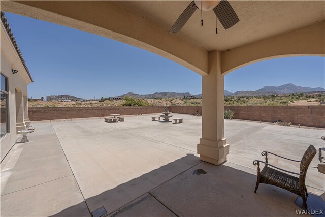 view of patio / terrace with a fenced backyard, a mountain view, and a ceiling fan