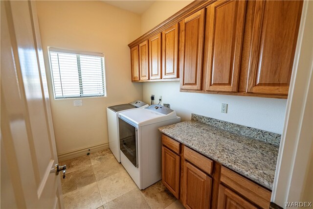 laundry room featuring baseboards, cabinet space, and washer and dryer