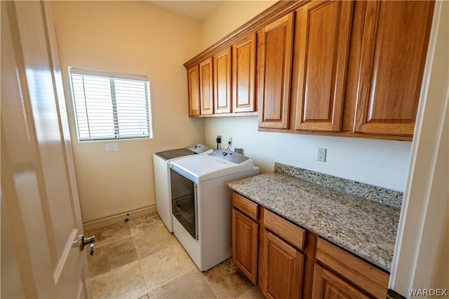 laundry room featuring baseboards, cabinet space, and washer and dryer